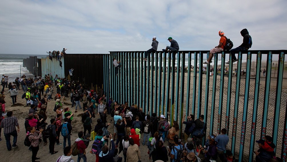 Migrantes tratan de cruzar el muro fronterizo Foto DPA
