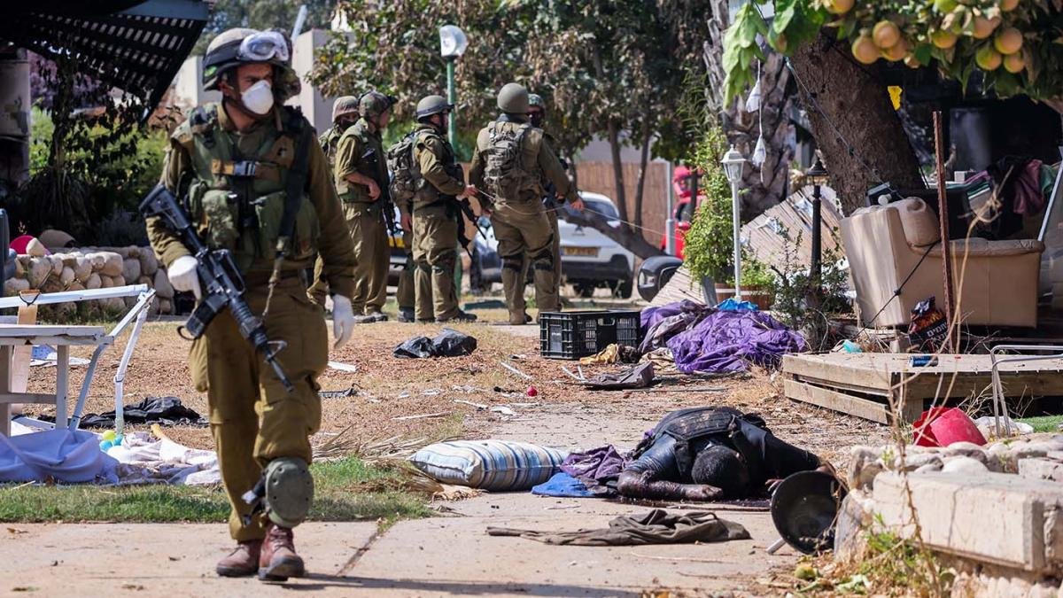 Soldados israeles junto al cadver de un militante palestino en Kfar Aza en el sur de Israel en la frontera con la Franja de Gaza Foto AFP